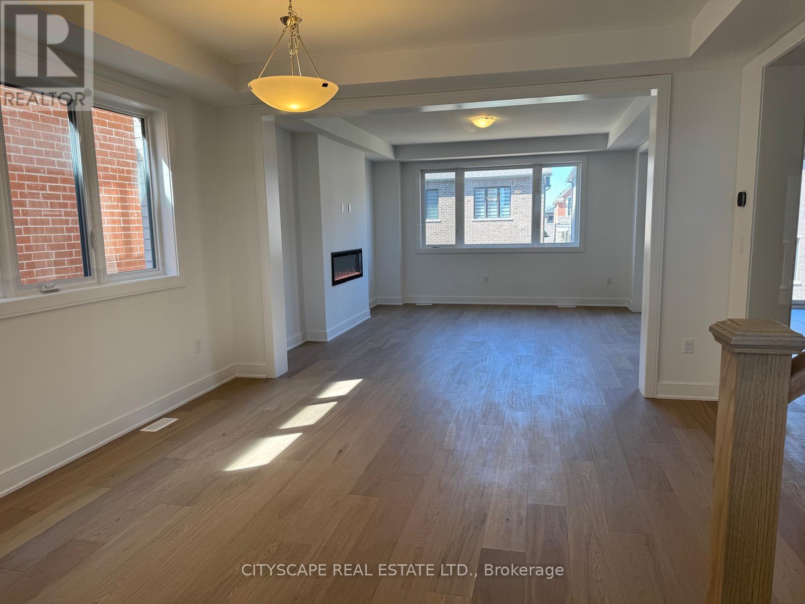 A spacious room with wooden floors and a large window.