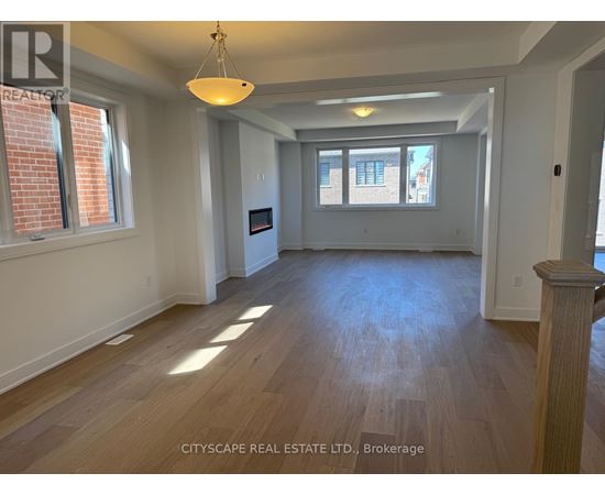 A spacious room with wooden floors and a large window.