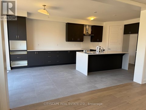 A kitchen with black cabinets and a white island.