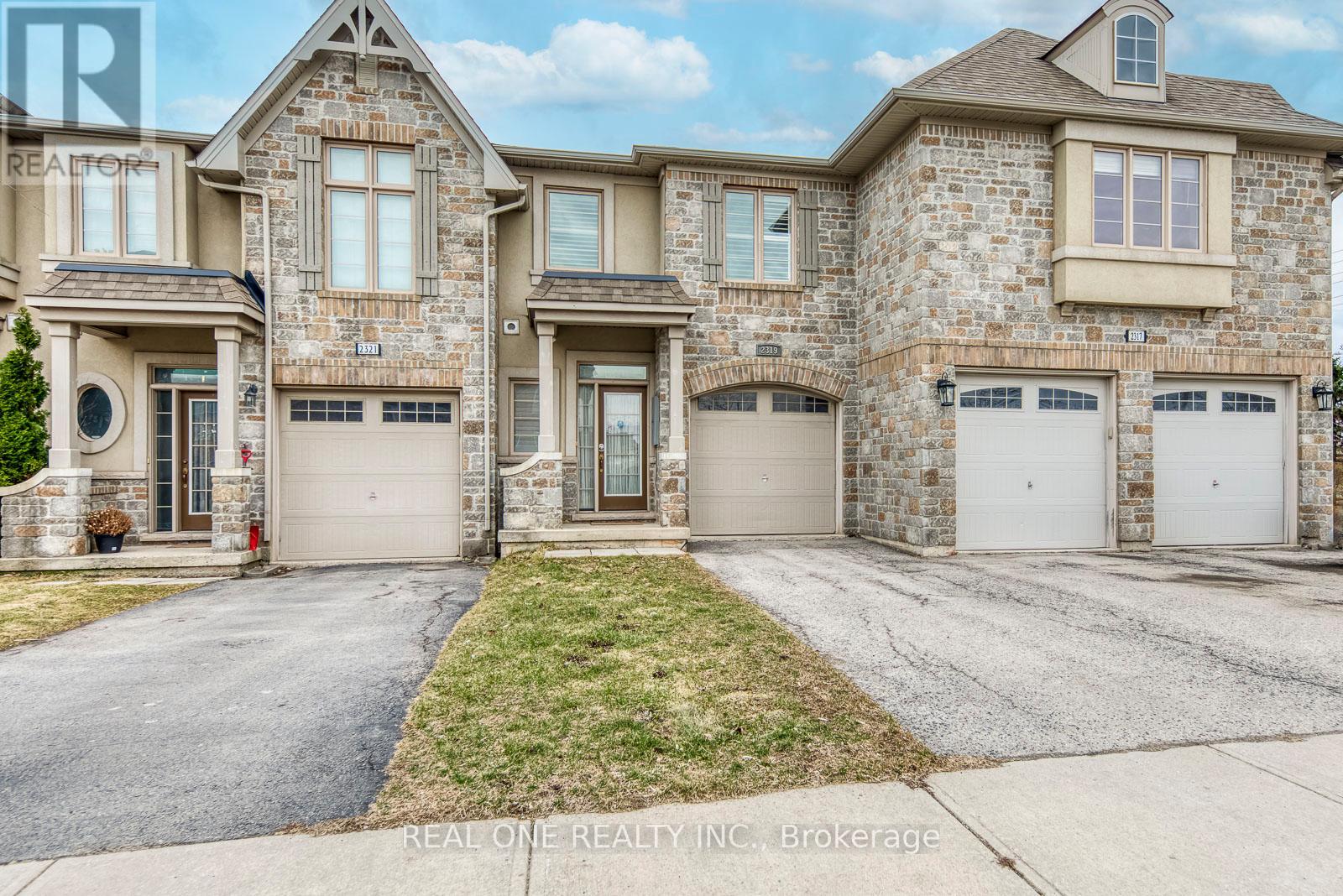 A large, two-story house with a stone facade and multiple garages.