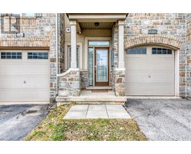 A stone building with a brown door and two garage doors.