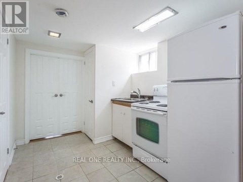 A white kitchen with a fridge, oven and microwave.