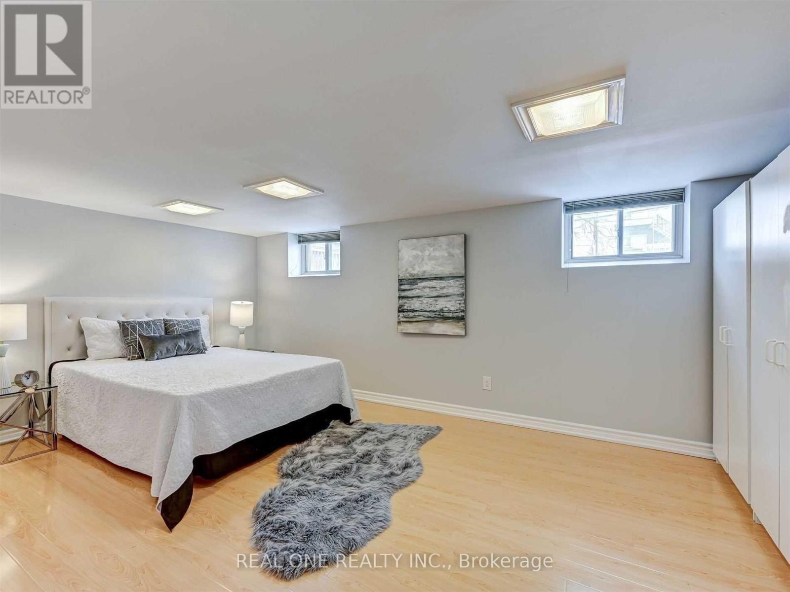 A bedroom with a large bed and a rug on the floor.