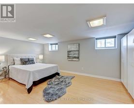 A bedroom with a large bed and a rug on the floor.