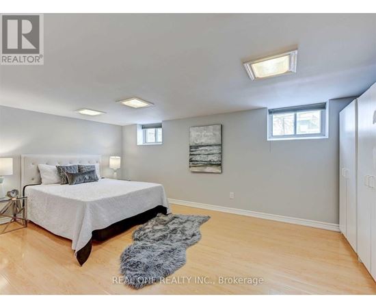 A bedroom with a large bed and a rug on the floor.
