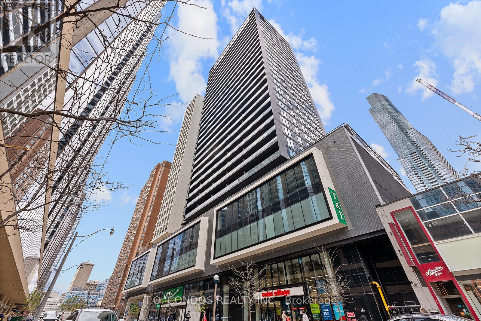 A tall building with a glass facade stands in front of a construction site.