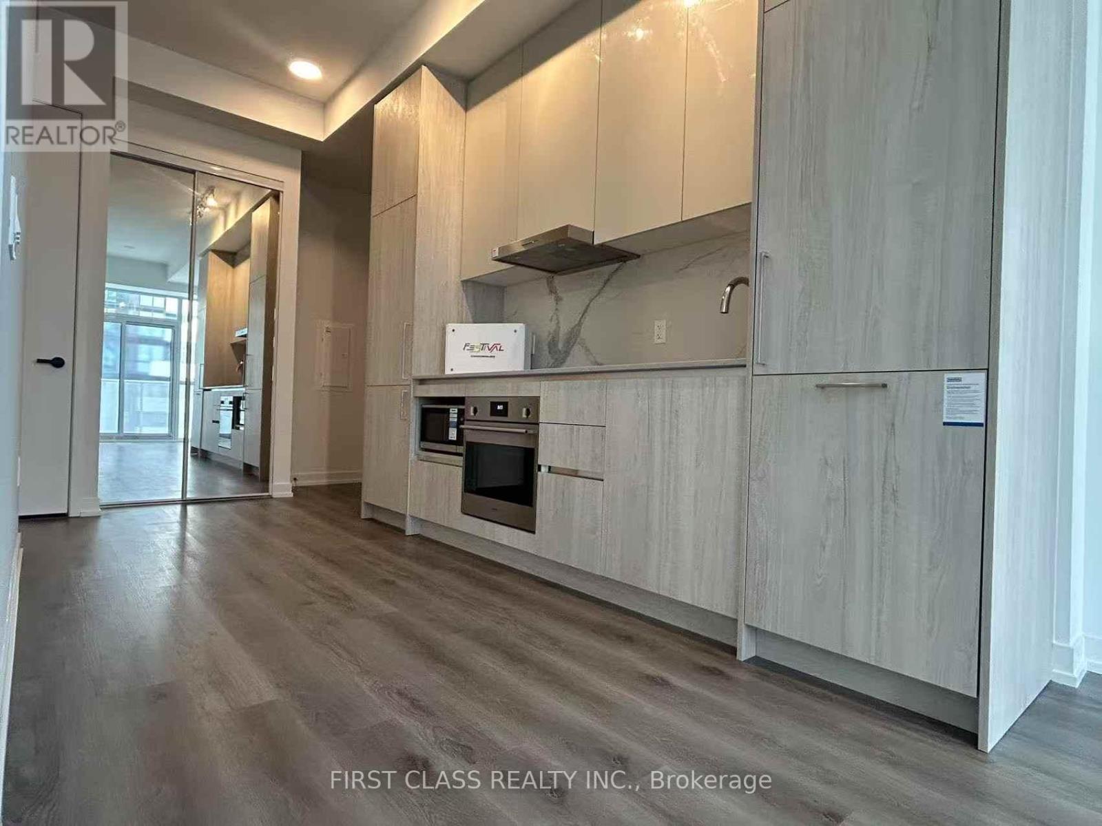 A kitchen with wooden cabinets and a stainless steel range hood.