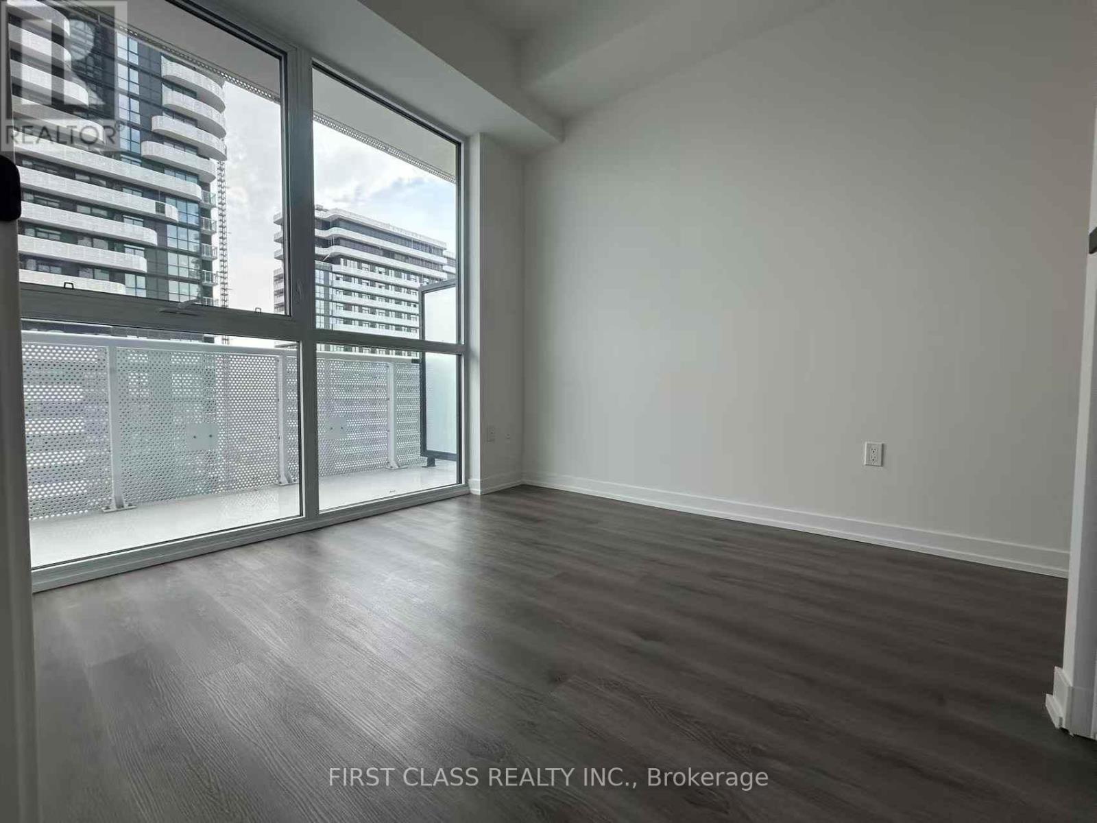 A room with a view of a cityscape through large windows.