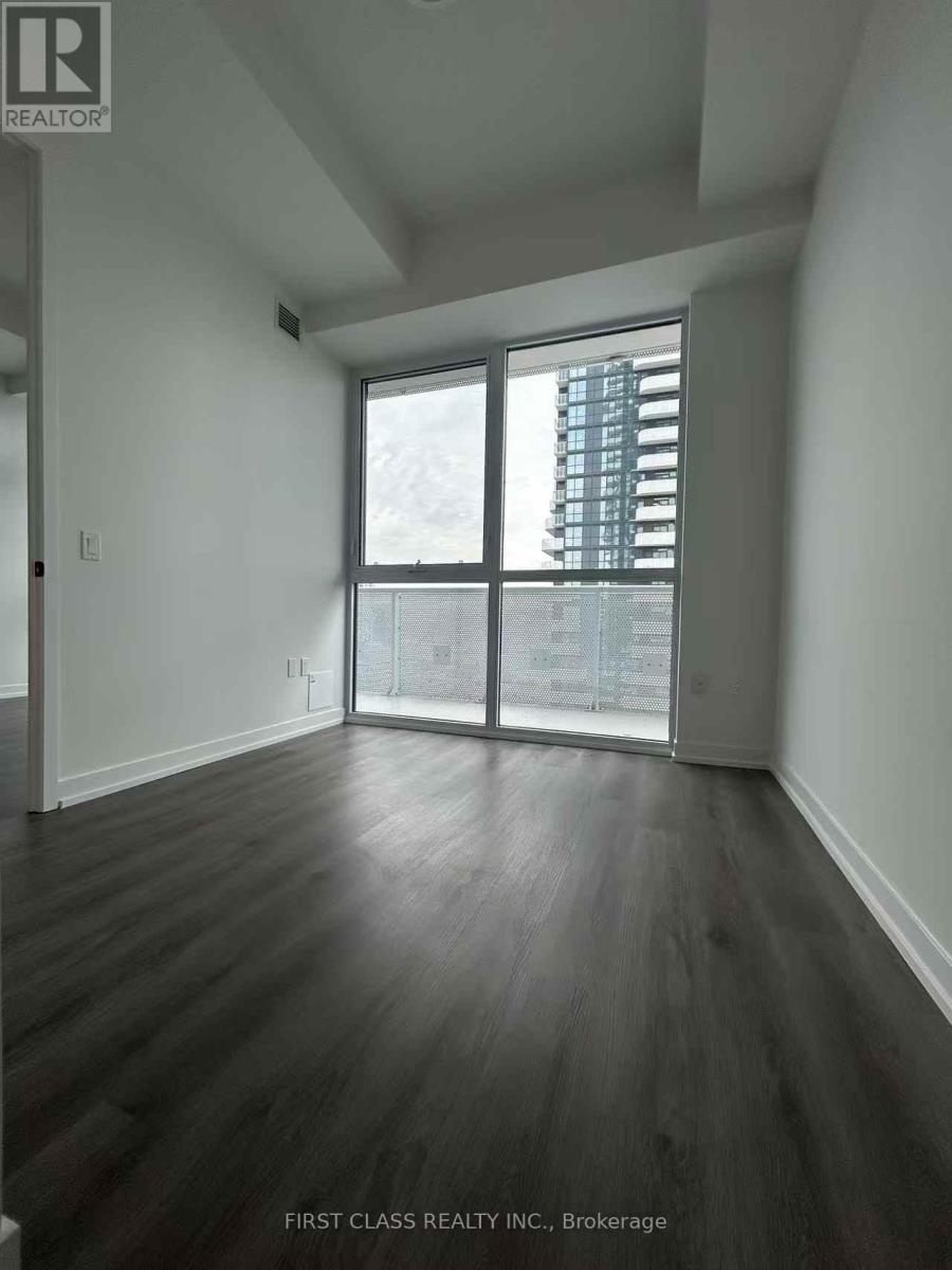 A room with wooden floors and a large window overlooking a cityscape.