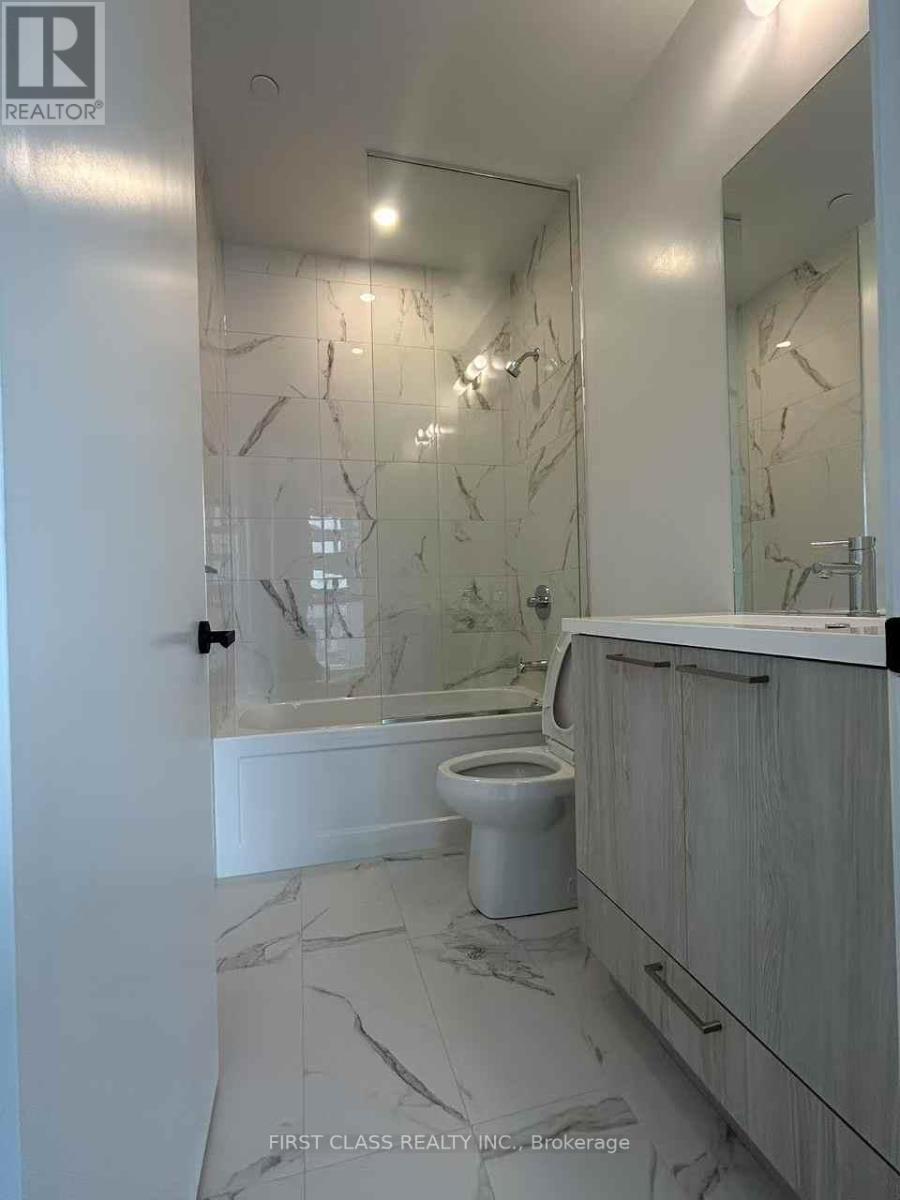 A bathroom with a marble floor and walls, a toilet, and a vanity with a mirror.