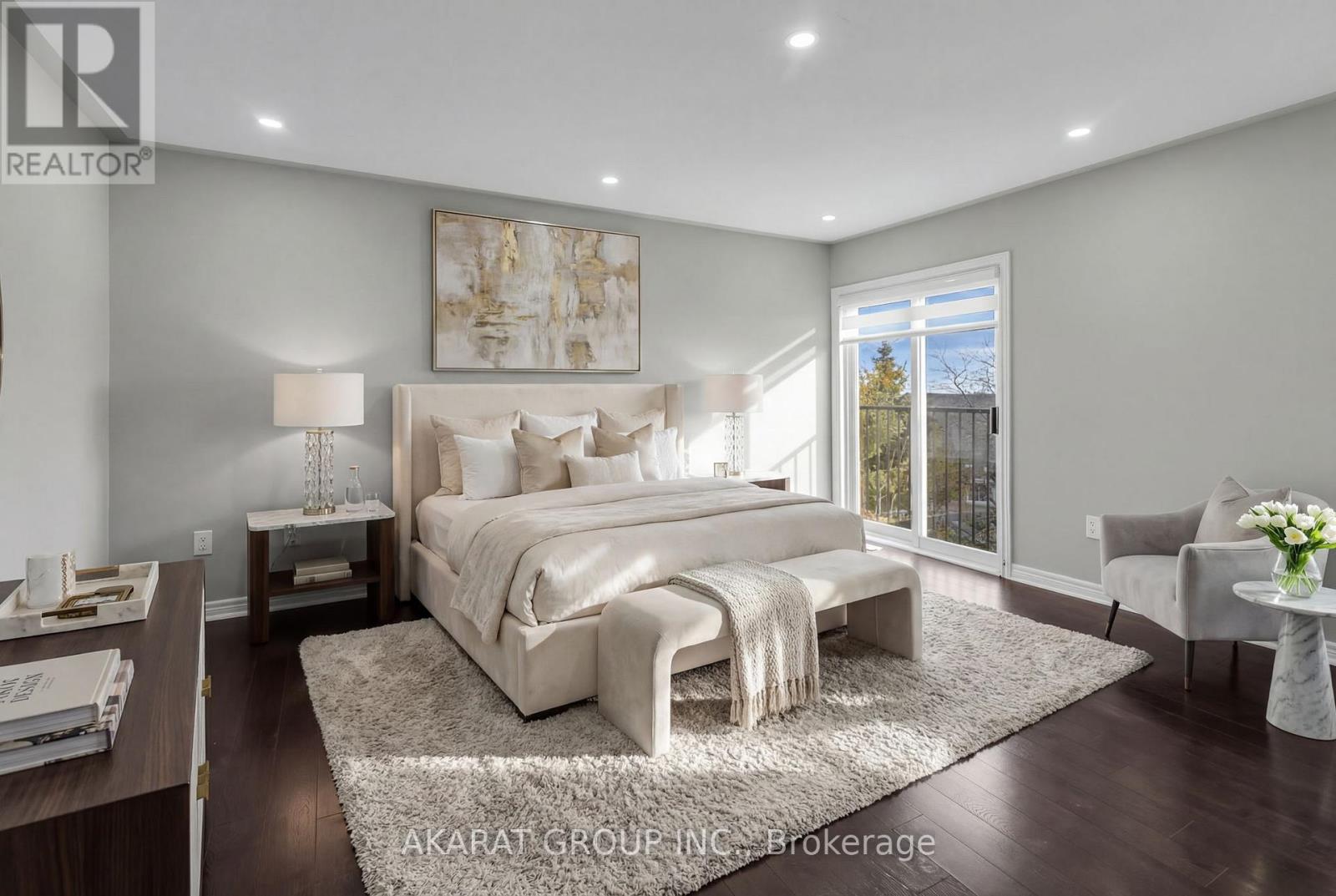 A well-lit bedroom with a large bed and a view of the outdoors through a sliding glass door.