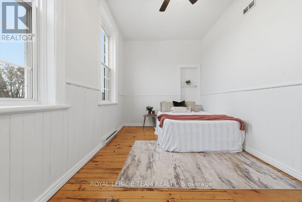 A bedroom with a bed, a rug, and a window.