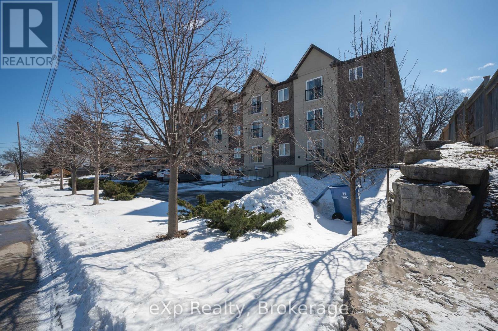 A building with a large tree in front of it is surrounded by snow.