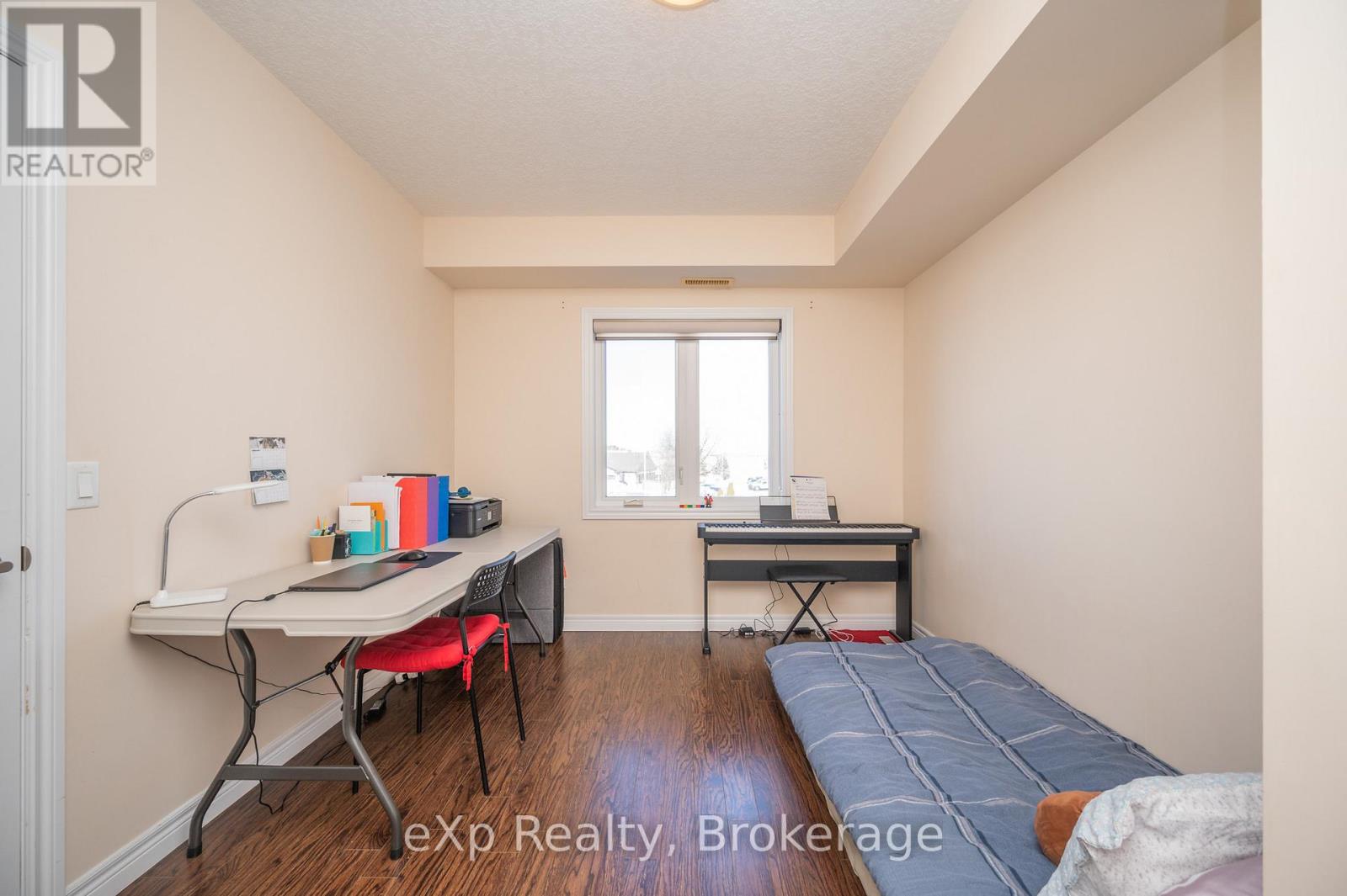 A bedroom with a bed, desk, and chair.