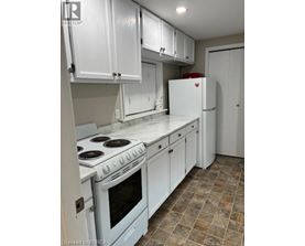 A kitchen with white cabinets and a white stove top oven.