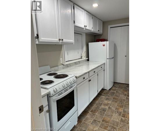 A kitchen with white cabinets and a white stove top oven.