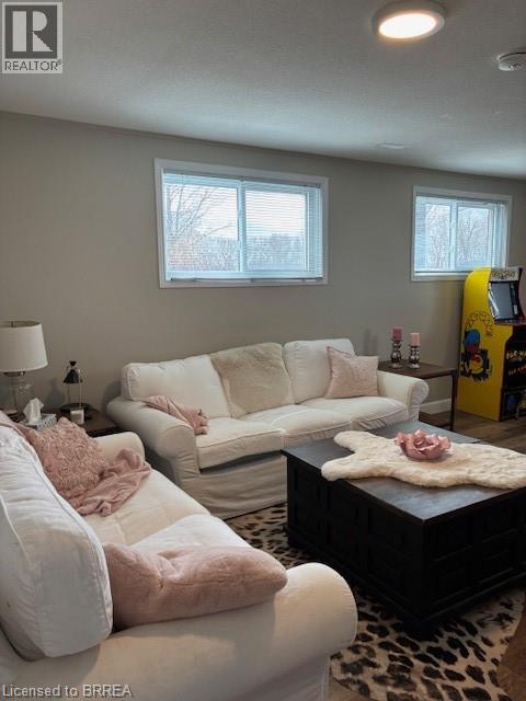 A living room with a white couch and a leopard print rug.