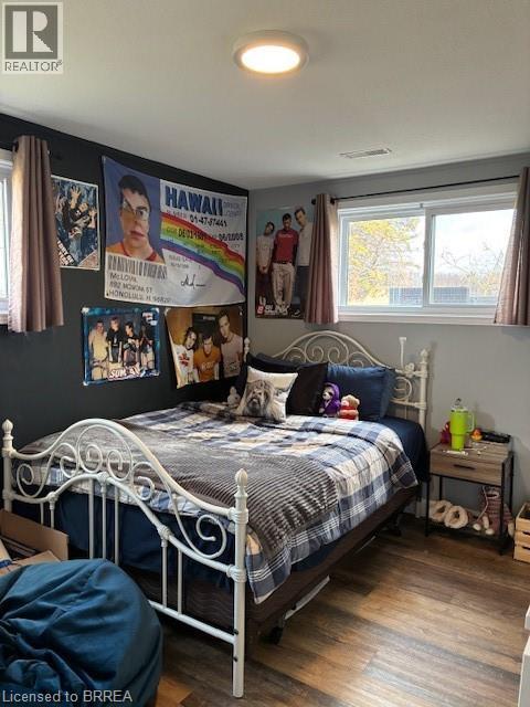 A bedroom with a bed, a window, and a poster on the wall.