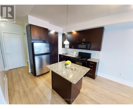 A kitchen with a granite countertop and stainless steel appliances.