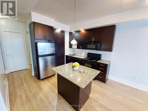 A kitchen with a granite countertop and stainless steel appliances.