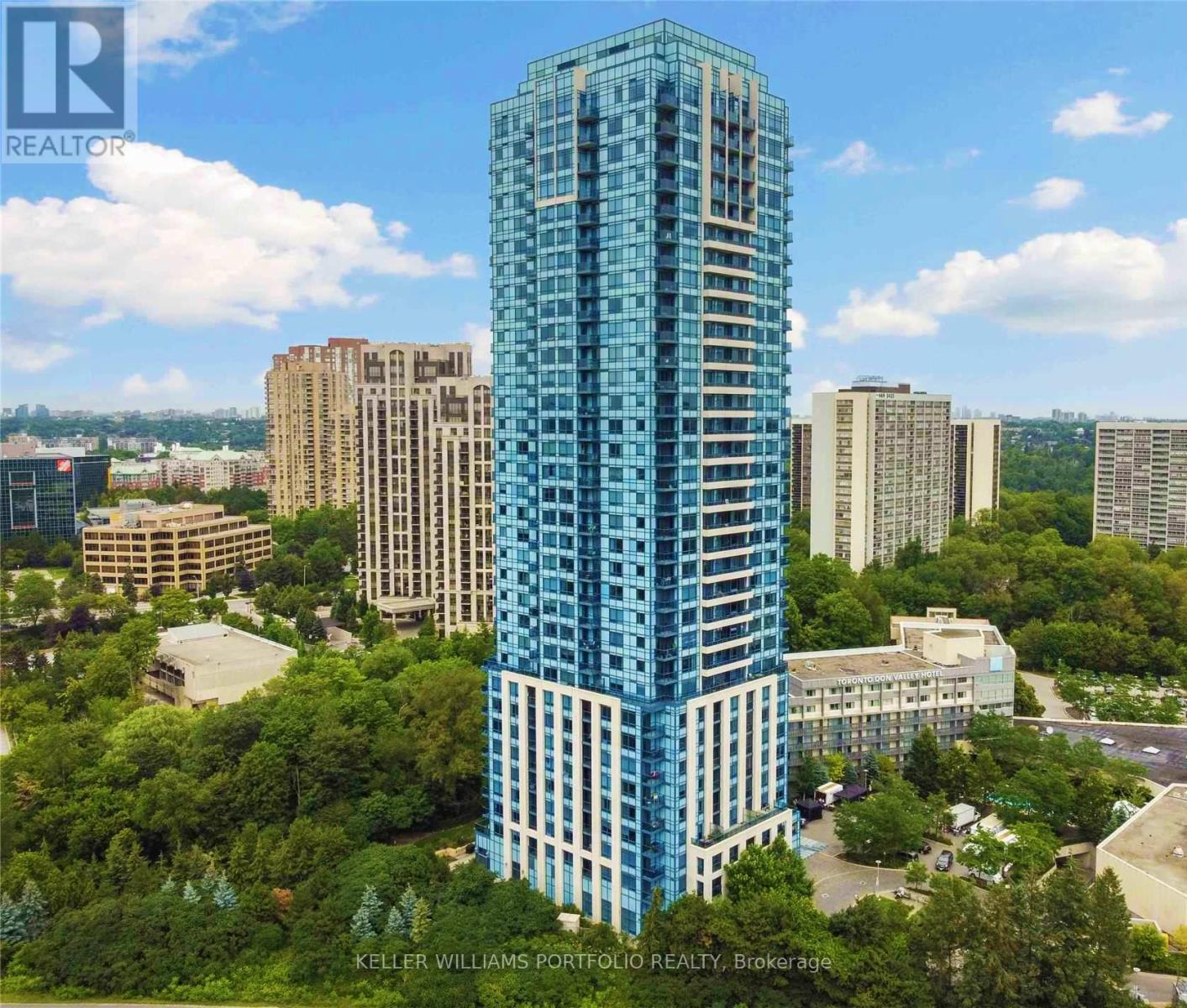 A tall blue building stands out in a cityscape.