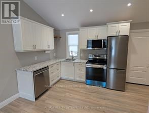 A kitchen with white cabinets and stainless steel appliances.
