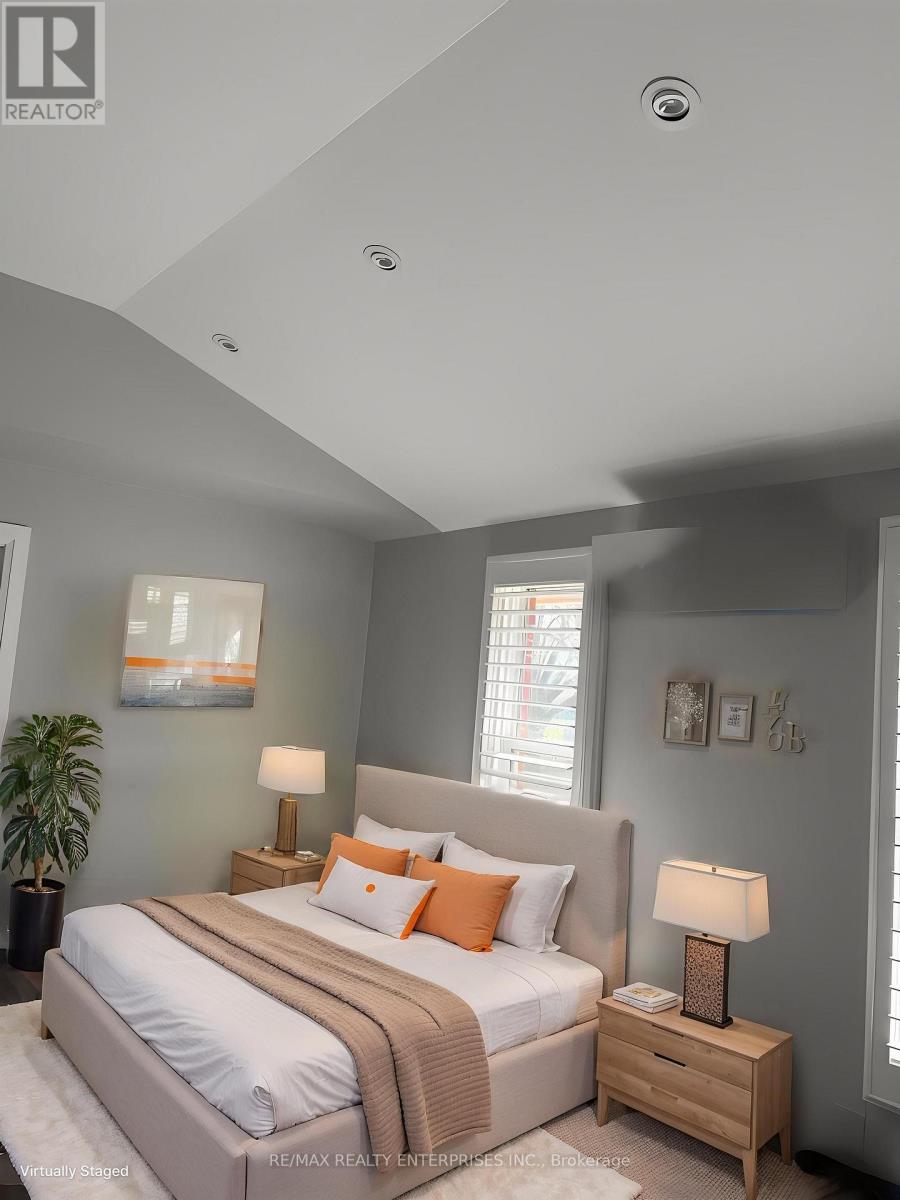 A bedroom with a large bed and a lamp on a nightstand.