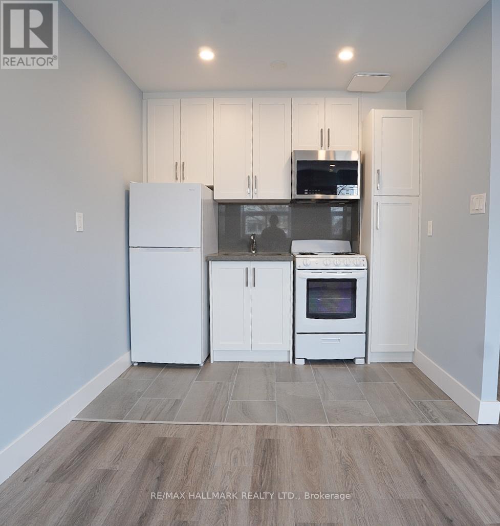A kitchen with white cabinets and appliances in a model home.