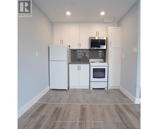 A kitchen with white cabinets and appliances in a model home.