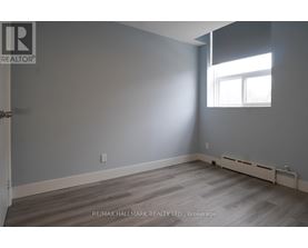 A room with a window and a door leading to another room.
