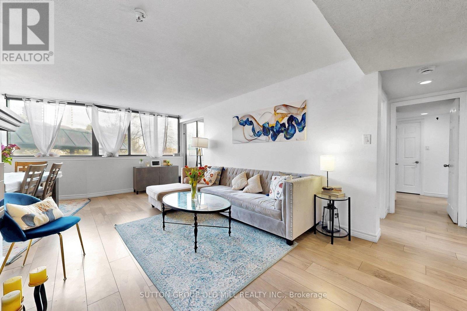 A living room with a blue rug and a white sofa.