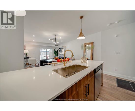 A modern kitchen with a large island and wooden cabinets.