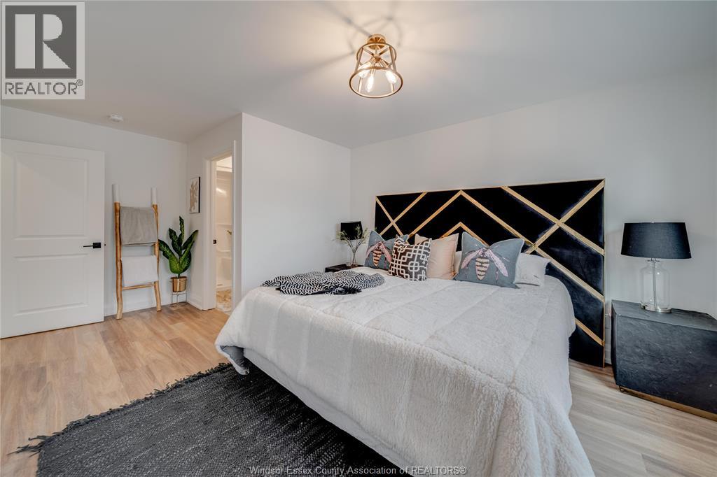 A bedroom with a large bed and a lamp on the side table.