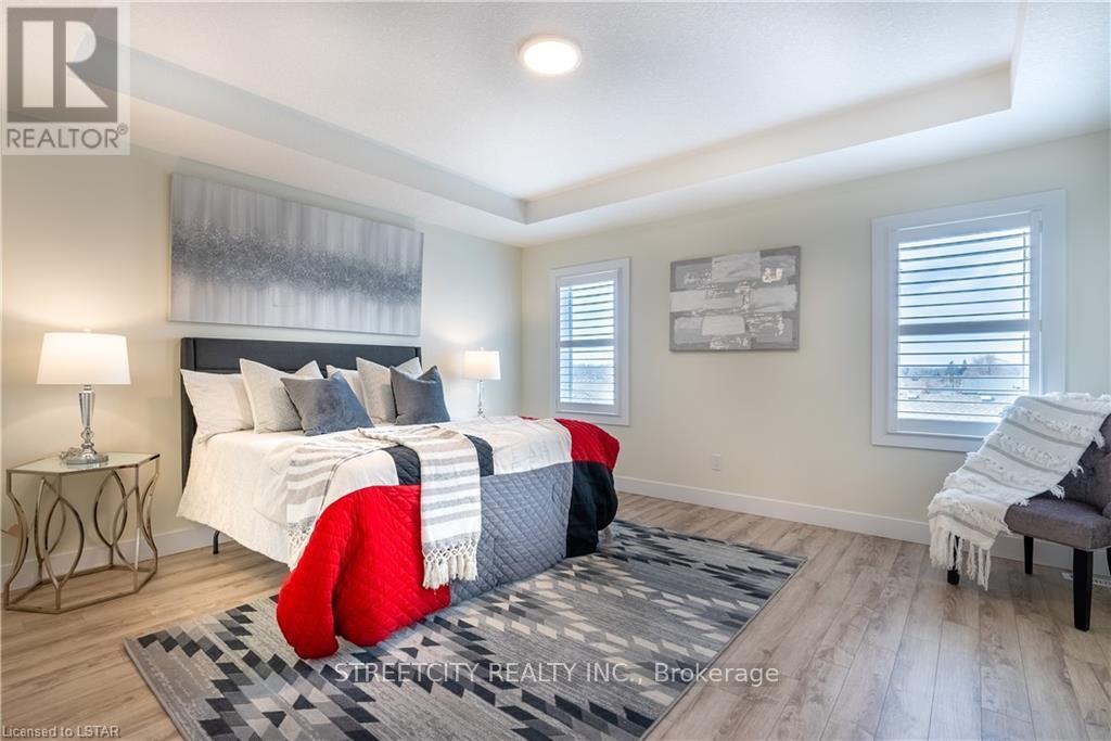 A bedroom with a large bed and a red chair.