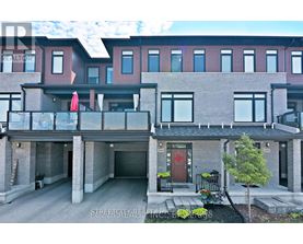 A modern two-story apartment building with a balcony and a red door.