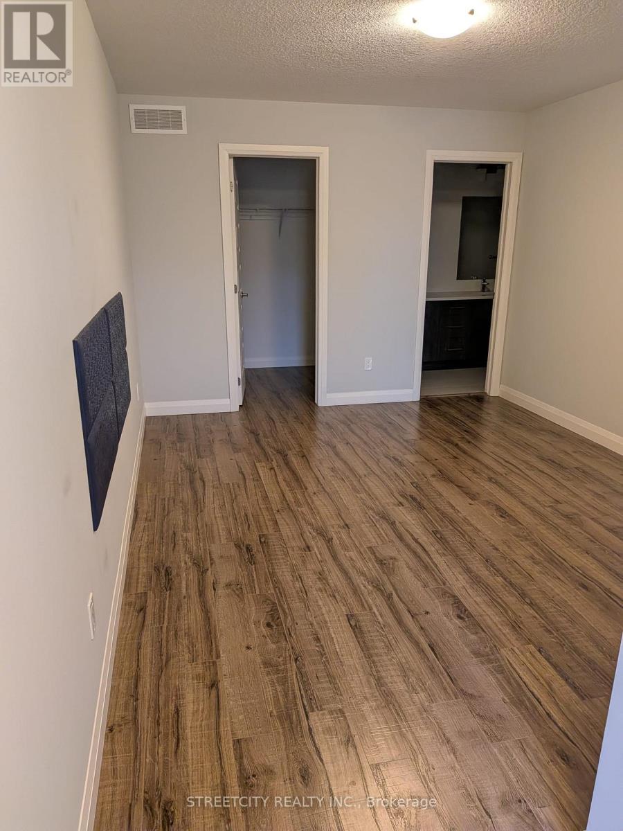 A room with wooden flooring and a flat screen TV mounted on the wall.