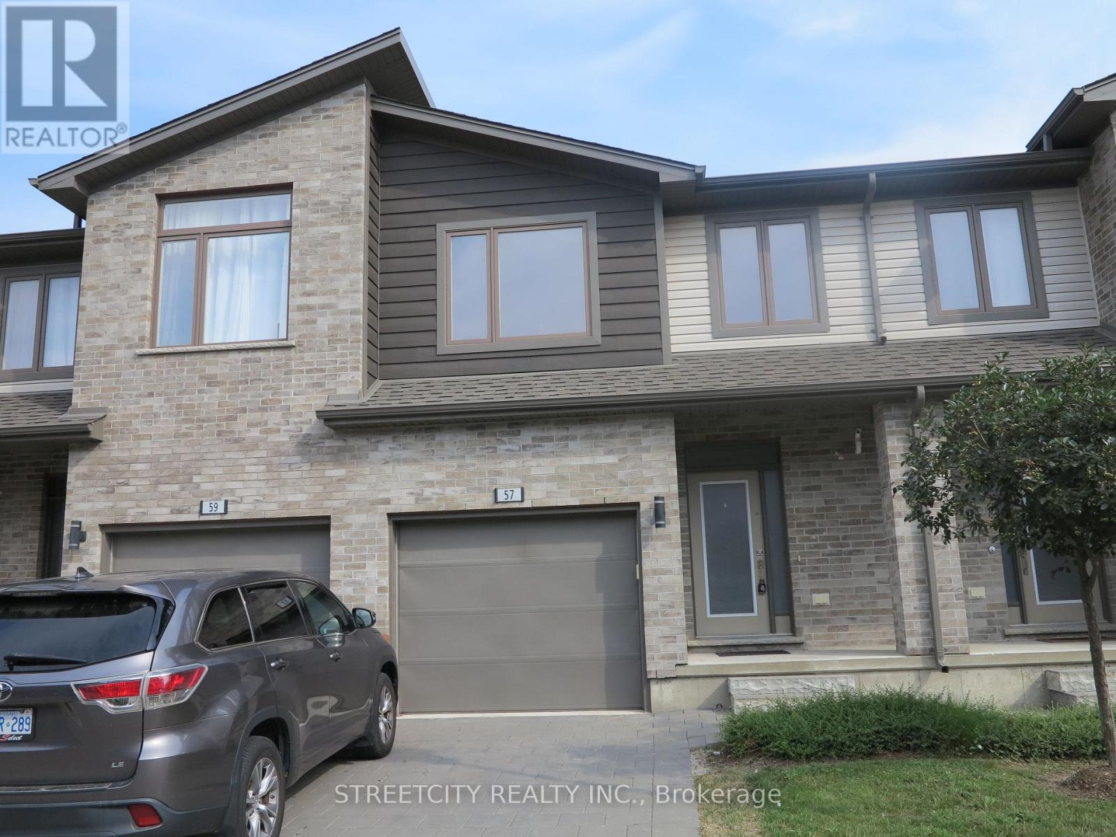A grey house with a car parked in front of it.