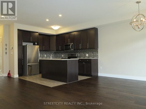 A kitchen with dark wood cabinets and a marble backsplash.