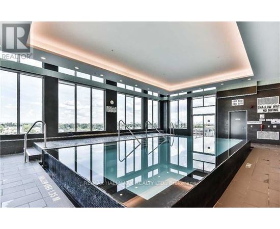 A large indoor swimming pool with a glass barrier and a sign that says "NO DIVING".