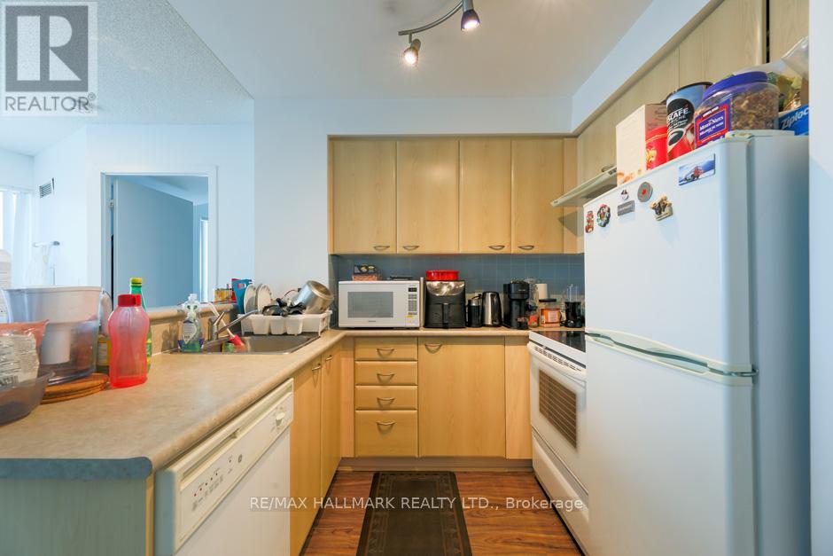 A kitchen with a white refrigerator, wooden cabinets, and a microwave.
