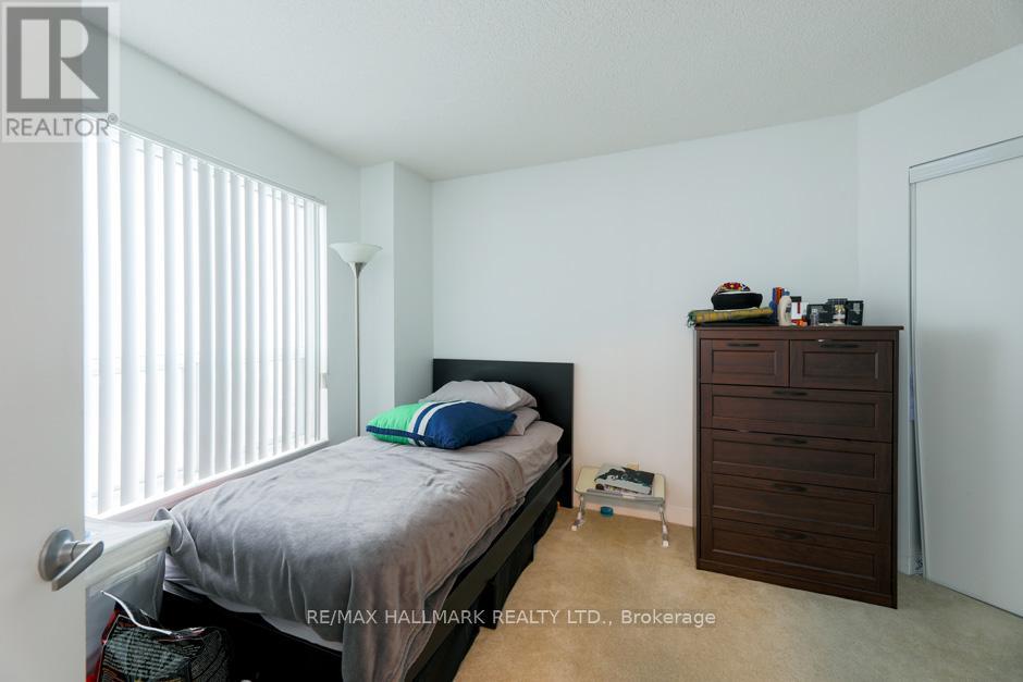 A bedroom with a bed, nightstand, and a wooden cabinet.