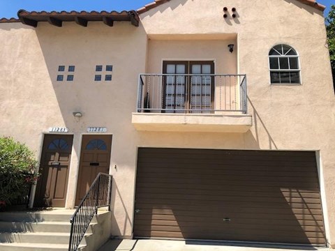 A two-story house with a balcony on the second floor.