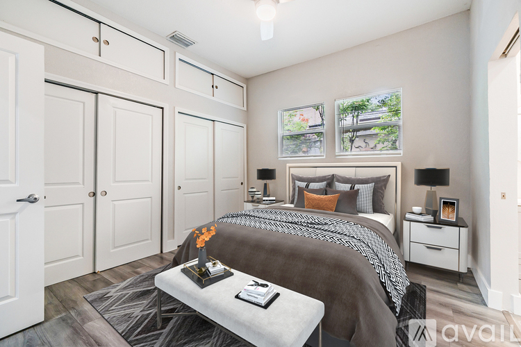 A bedroom with a large bed and a bench in front of it.