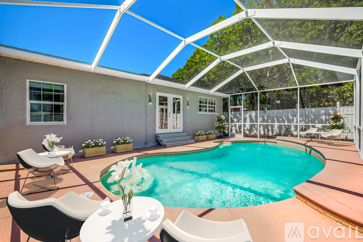 A poolside patio with chairs and a table.