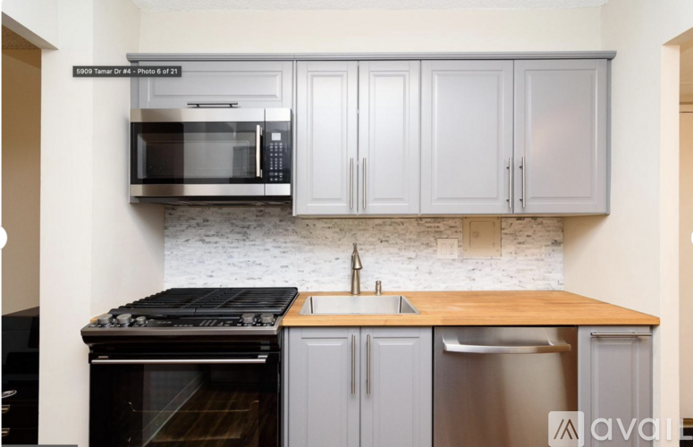 A kitchen with a stove, microwave, and cabinets.