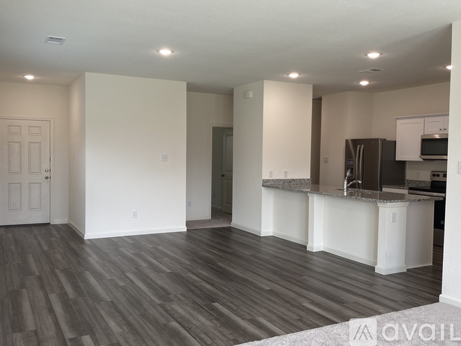 A spacious kitchen with a bar area and a dining room with a door.