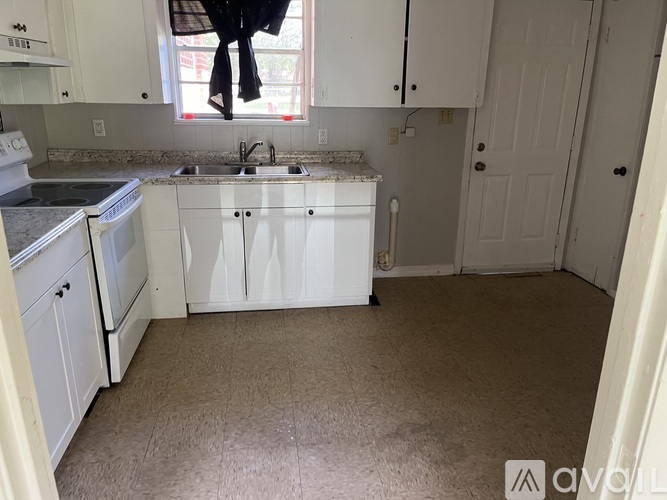 A kitchen with white cabinets and a sink.