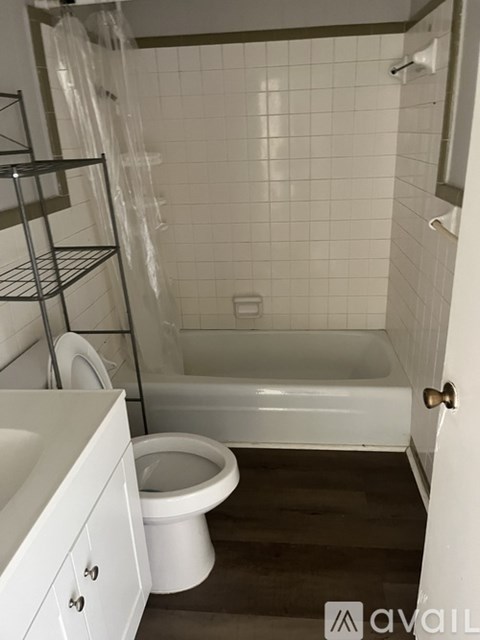 A white toilet sits next to a white bathtub in a bathroom.