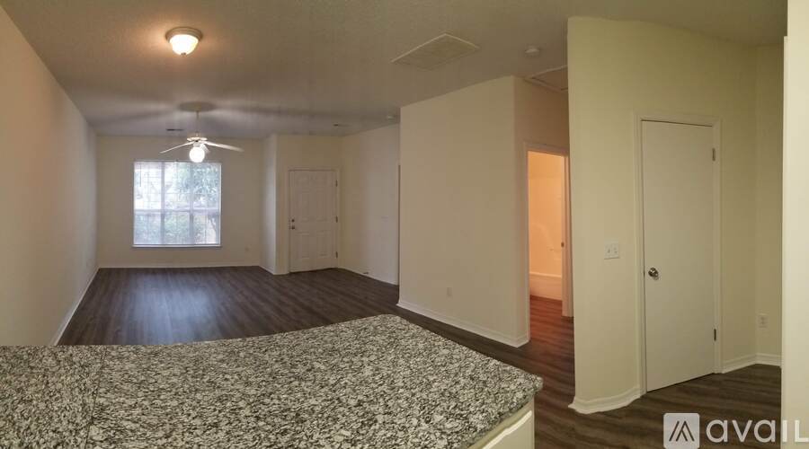 A bedroom with a bed, a window, and a ceiling fan.