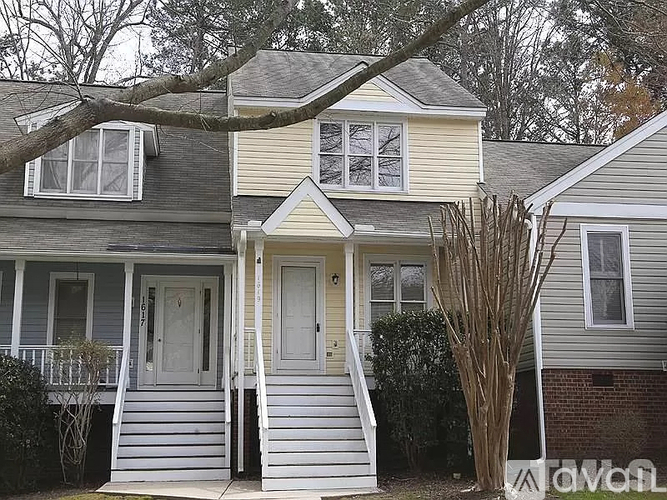 A two-story house with a grey roof and white siding.